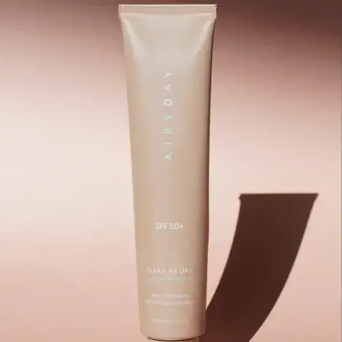 Standing Airyday Clear as Day SPF50+ tube on a mauve surface with a long cast shadow